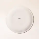 A plain white plate with a small text "made.in" in the center sits against a light background.