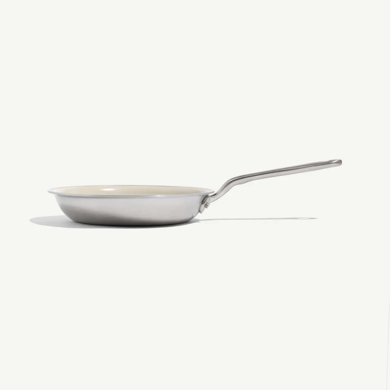 A stainless steel frying pan with a long handle is displayed against a light background.