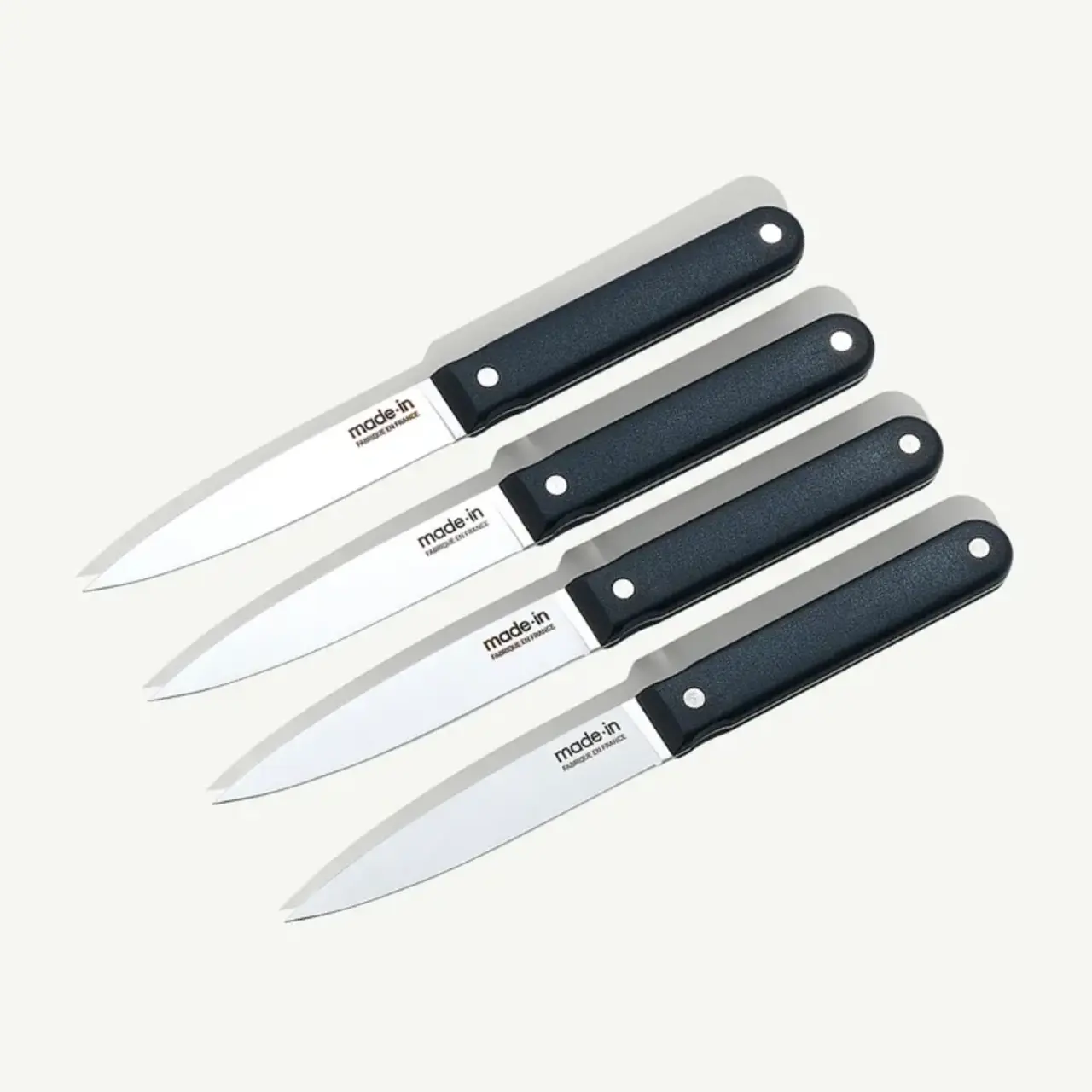 Four identical kitchen knives with dark handles are arranged in parallel on a light background.