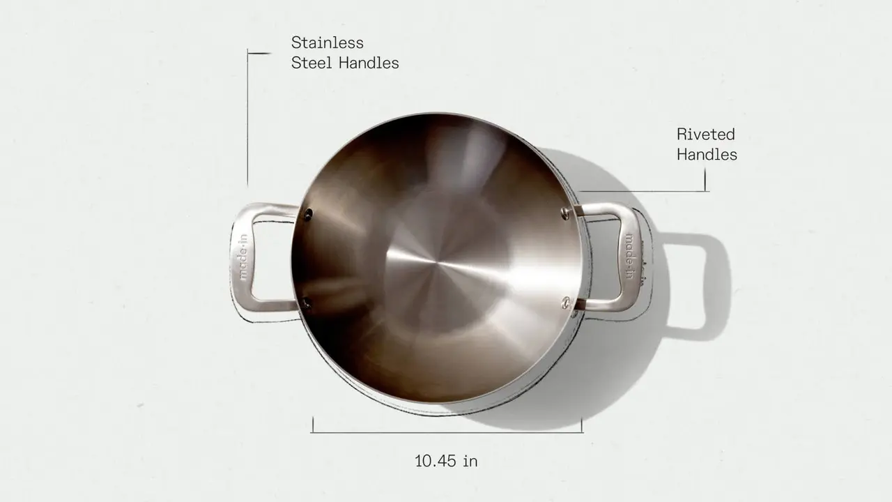 A top-down view of a stainless steel pan with labeled stainless steel riveted handles and a measurement of 10.45 inches across the pan.