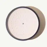 A top-down view of a minimalist design speaker with a circular pattern on its surface and a dark rim.