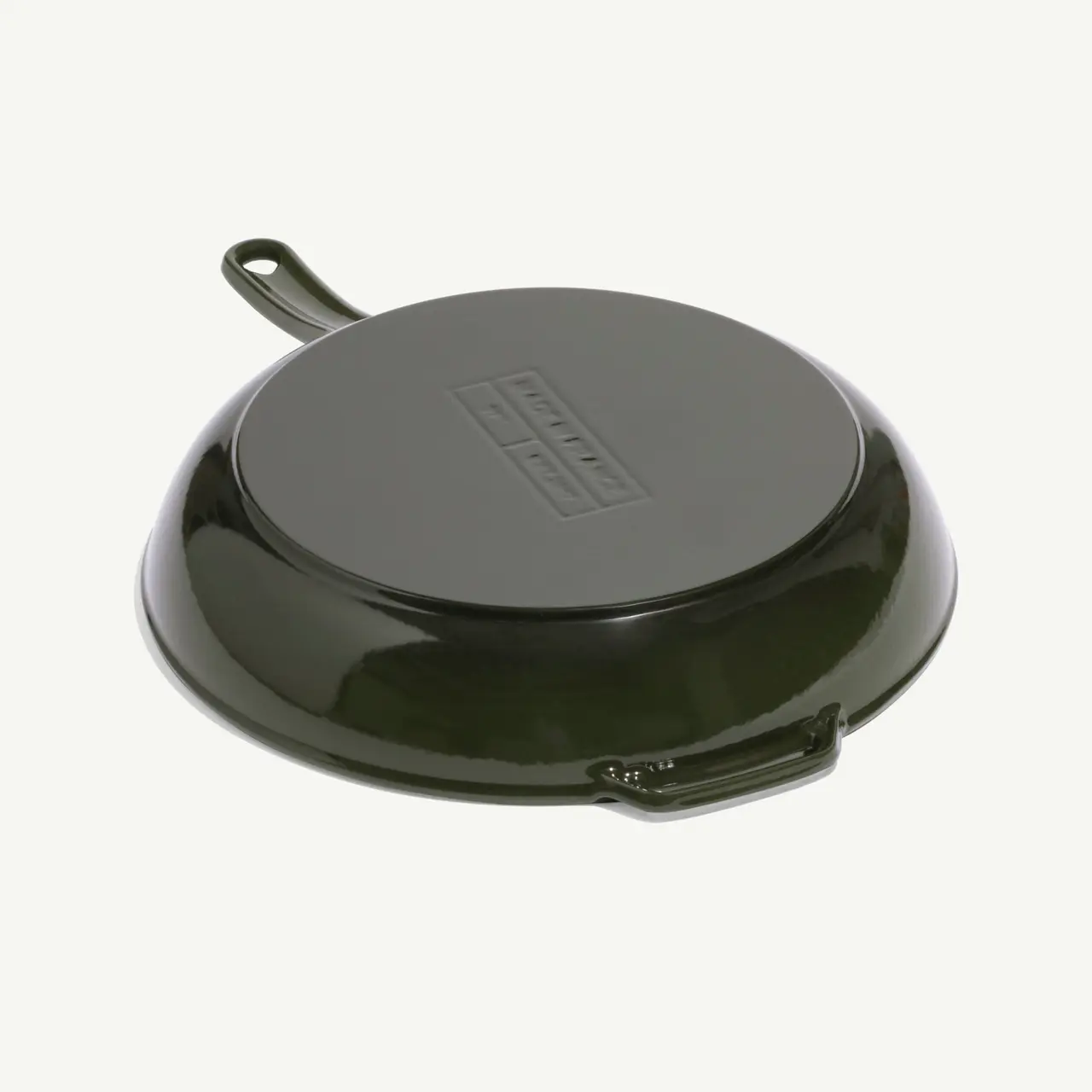 A dark green enameled cast iron skillet with a smooth surface and a handle.