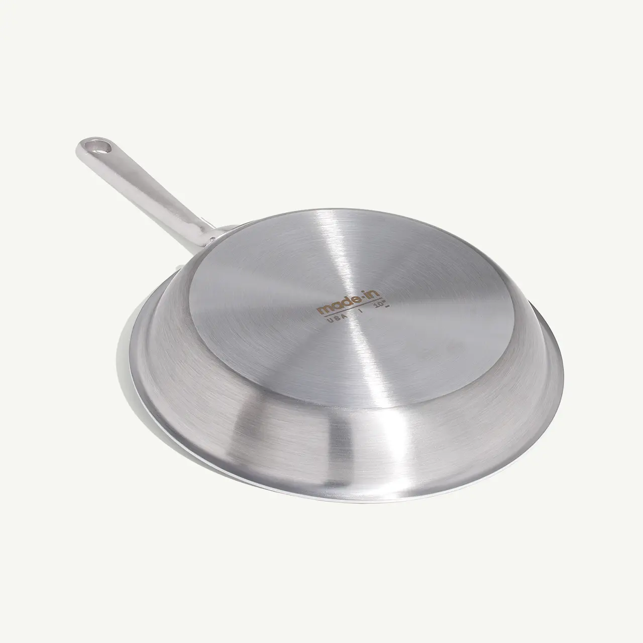 A stainless steel frying pan with a long handle is displayed against a neutral background.