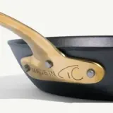 A close-up of a pan with a wooden handle, showing an engraving that reads "MADE IN ITALY."
