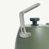 A sleek, green kettle features a stainless steel handle and lid knob, with a "MADE IN" tag visible on the handle.