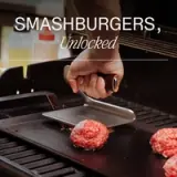 A hand holds a spatula above raw ground beef patties on a grill, with the text "SMASHBURGERS, Unlocked" displayed prominently.