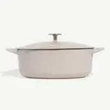 A modern beige-colored Dutch oven with a lid on a white background.