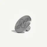 A metallic button featuring a prominent engraved letter "N" on its surface.