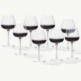 A collection of eight elegant wine glasses filled with red wine, arranged in a visually appealing layout.