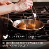 A hand holds a spoon above a pan with two seared scallops, accompanied by text stating "30 out of 30 tests passed for safety and quality" and "Light Labs Certified."