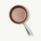 A new non-stick frying pan with a silver handle is positioned against a light background.