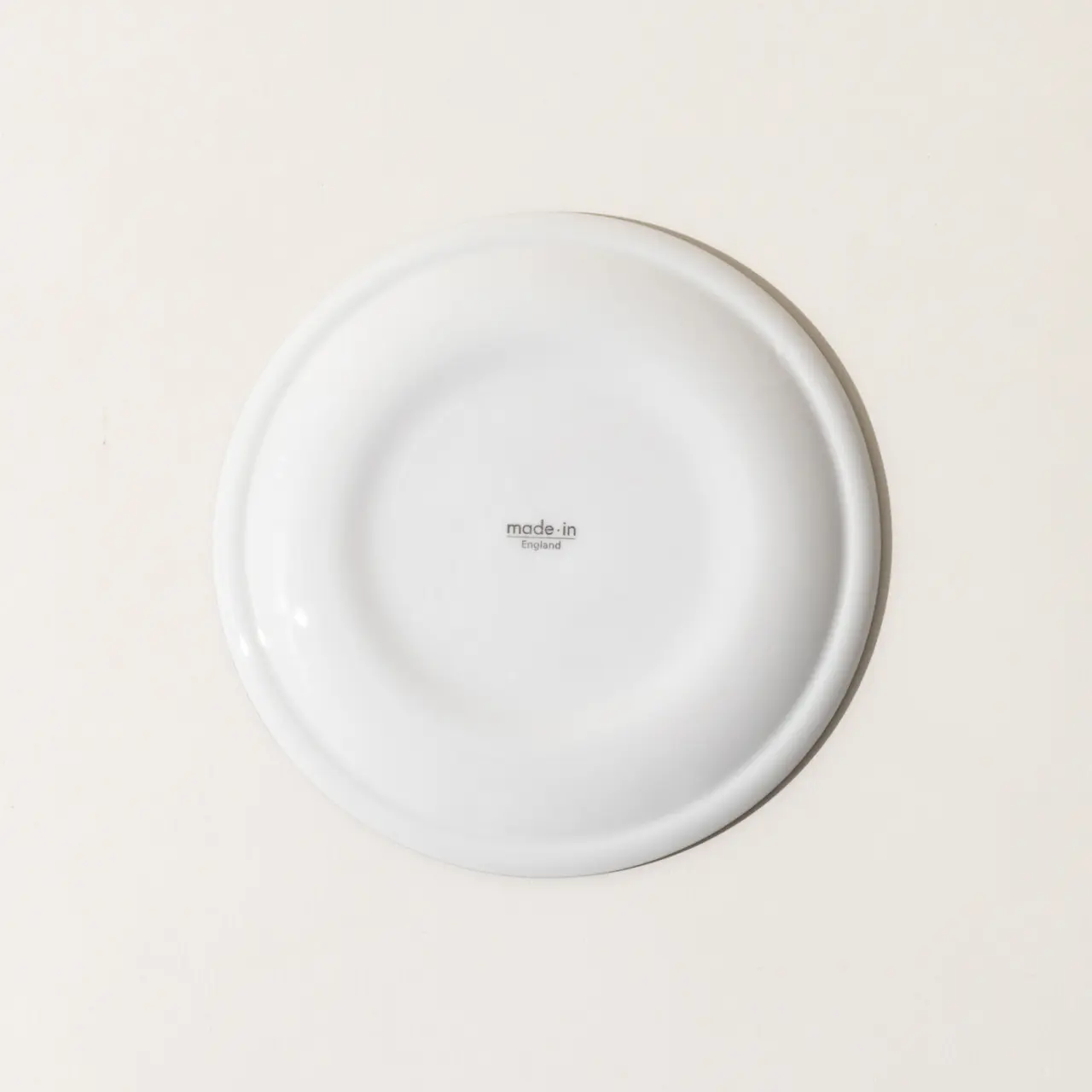 A plain white plate with the text "made.in" at the center on a light background.