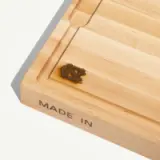 A wooden cutting board features a carved "UNC" logo and displays the phrase "MADE IN" on the side.