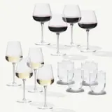 A variety of wine glasses, including red and white wine glasses, are arranged alongside several clear glasses filled with ice.