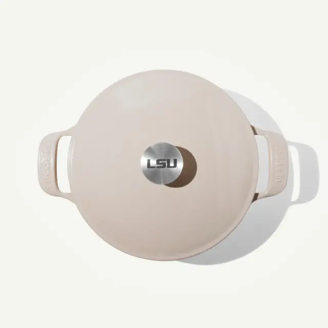 A light-colored cooking pot with a glossy finish and an "LSU" emblem on the lid.
