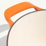 A close-up view of a beige object with an orange handle that reads "modern."