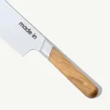 A kitchen knife with a wooden handle and "made.in" engraved on the blade.