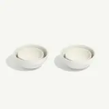 Two sets of white ceramic nesting bowls are placed side by side on a plain background.