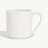 A white ceramic mug with a handle is centered against a plain background.
