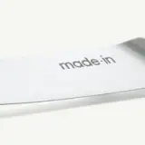 A close-up view of a knife blade with the words "made in" inscribed on it.