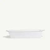 A rectangular white ceramic baking dish with handles on both sides is centered against a plain background.