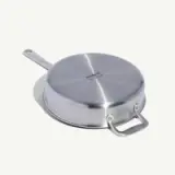 A stainless steel pan is shown upside down with a handle and a helper handle visible.