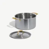 A stainless steel cooking pot with a lid, featuring gold-colored handles.