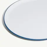 A round white plate with a blue rim, set against a plain background.