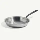 A stainless steel frying pan with a black handle on a light background.