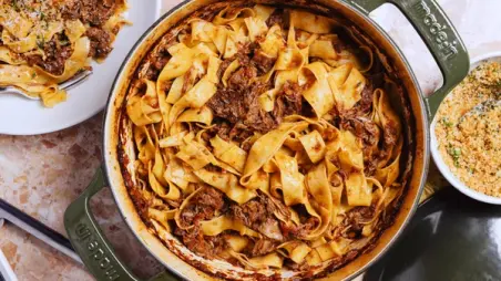 Pappardelle with braised meat sauce in a Made In Dutch Oven, served with grated cheese.