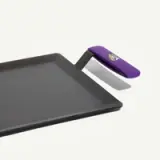 A rectangular griddle with a black non-stick cooking surface and a purple handle.
