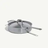 A stainless steel deep skillet with a lid and two handles is shown against a plain background.