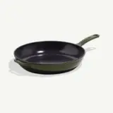 A cast iron skillet with a green exterior and a black interior, designed for cooking.
