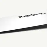 A close-up of a knife blade with the word "made:in" printed on it.