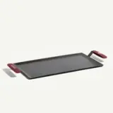A flat, rectangular cooking griddle with red handles on each side.