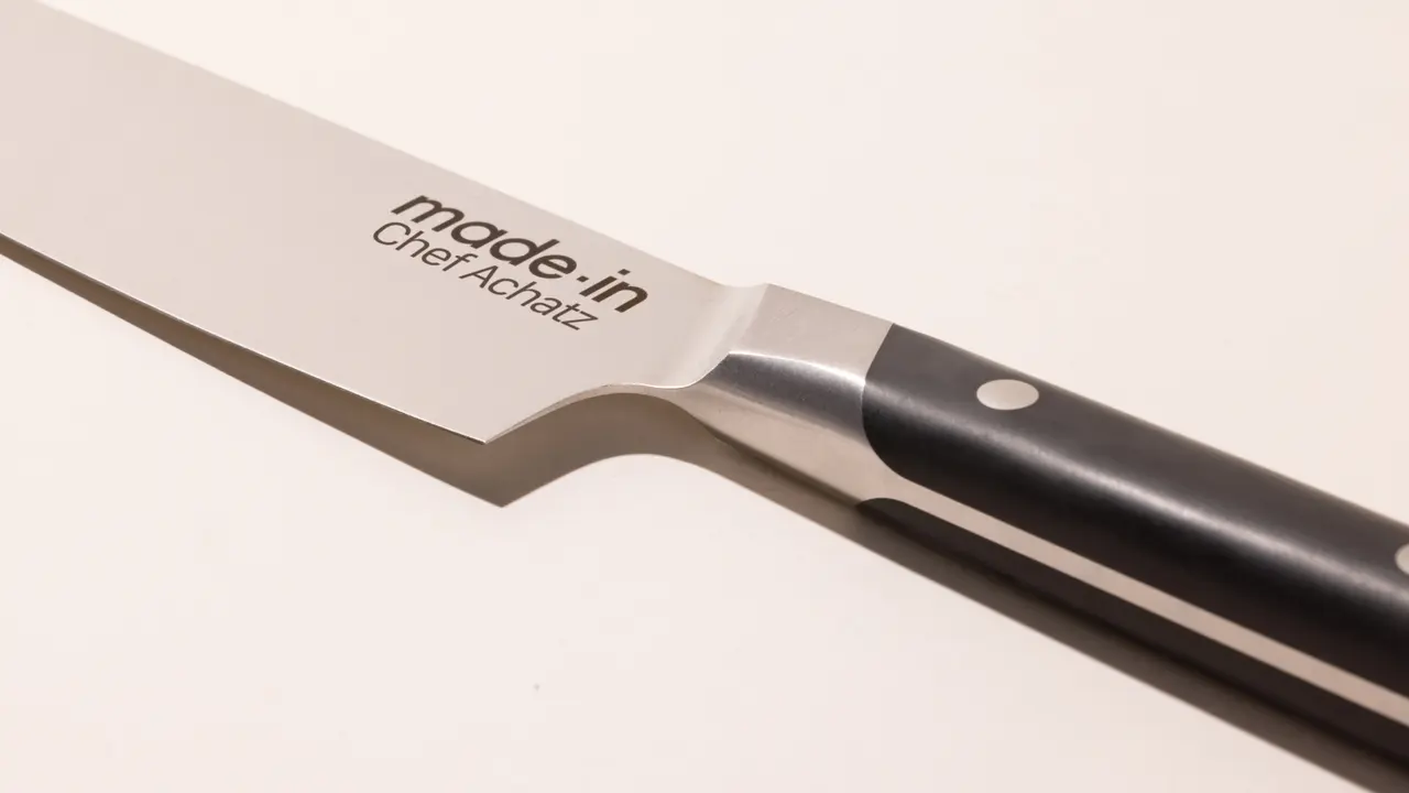 A close-up of a chef's knife blade showing the text "made in Chef Alexia."