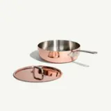 A copper saucepan with a stainless steel interior and a matching lid are displayed against a white background.
