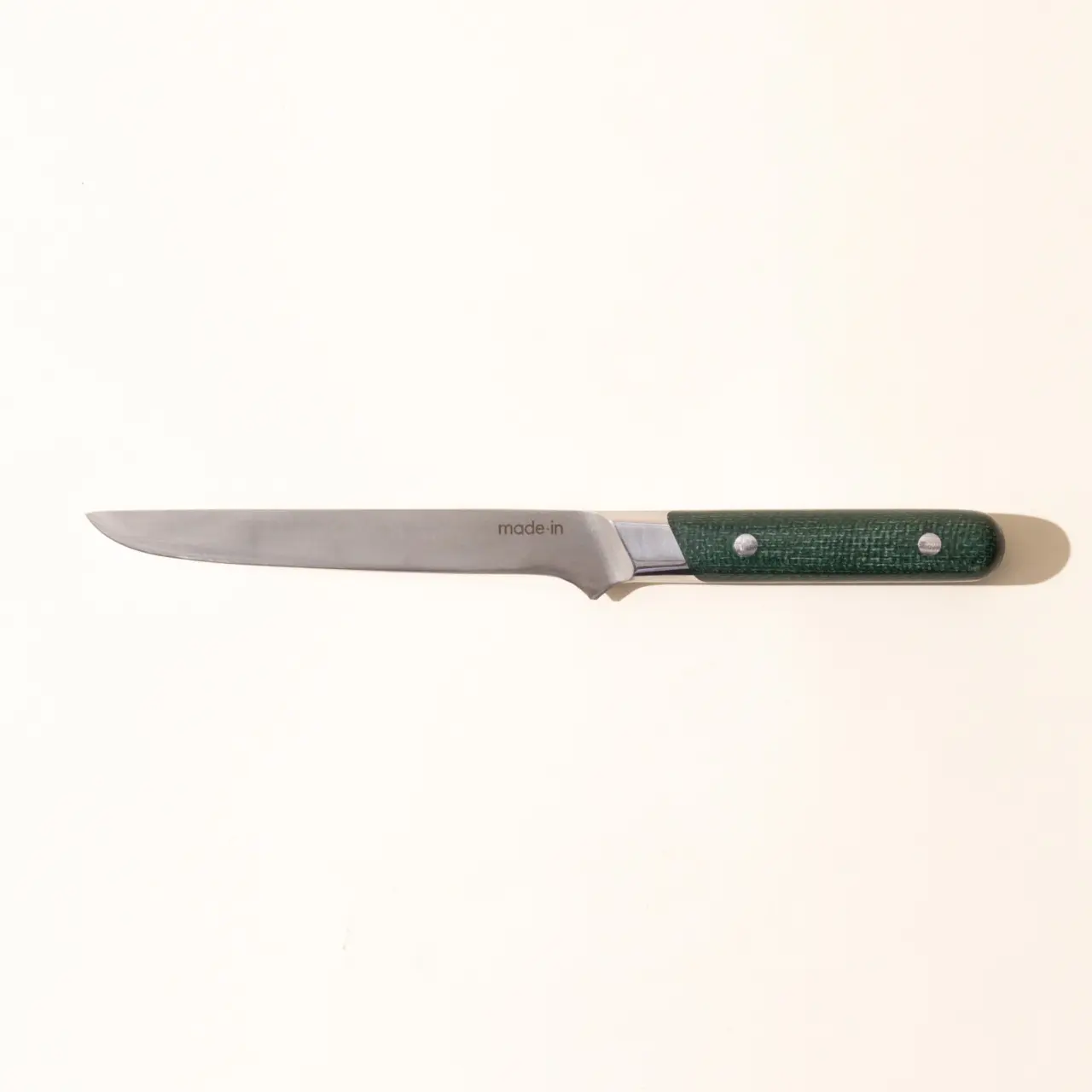 A kitchen knife with a green handle against a white background.