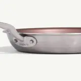 A stainless steel frying pan with a copper-colored interior and the brand name "made•in" engraved on the handle.