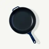 A black cast iron skillet with a white handle is viewed from above.