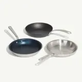 Three frying pans with different finishes are arranged on a white background.