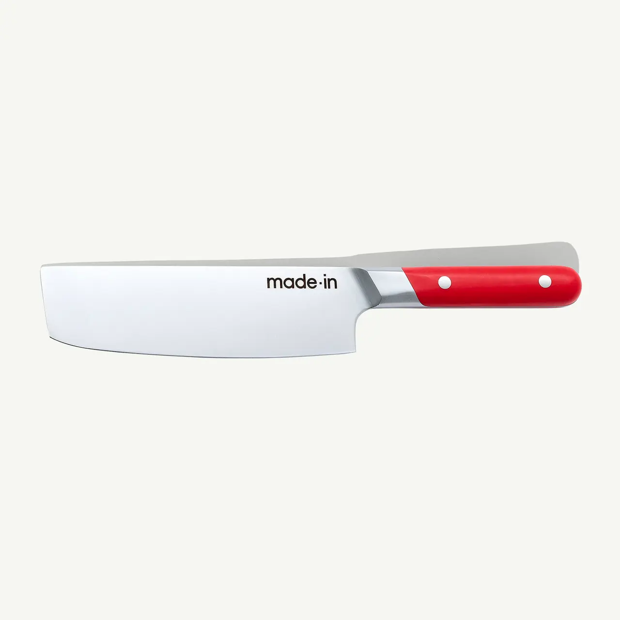 A stainless steel chef's knife with a red handle lies against a light background.