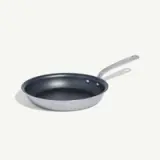 A silver frying pan with a non-stick black interior and a metal handle.