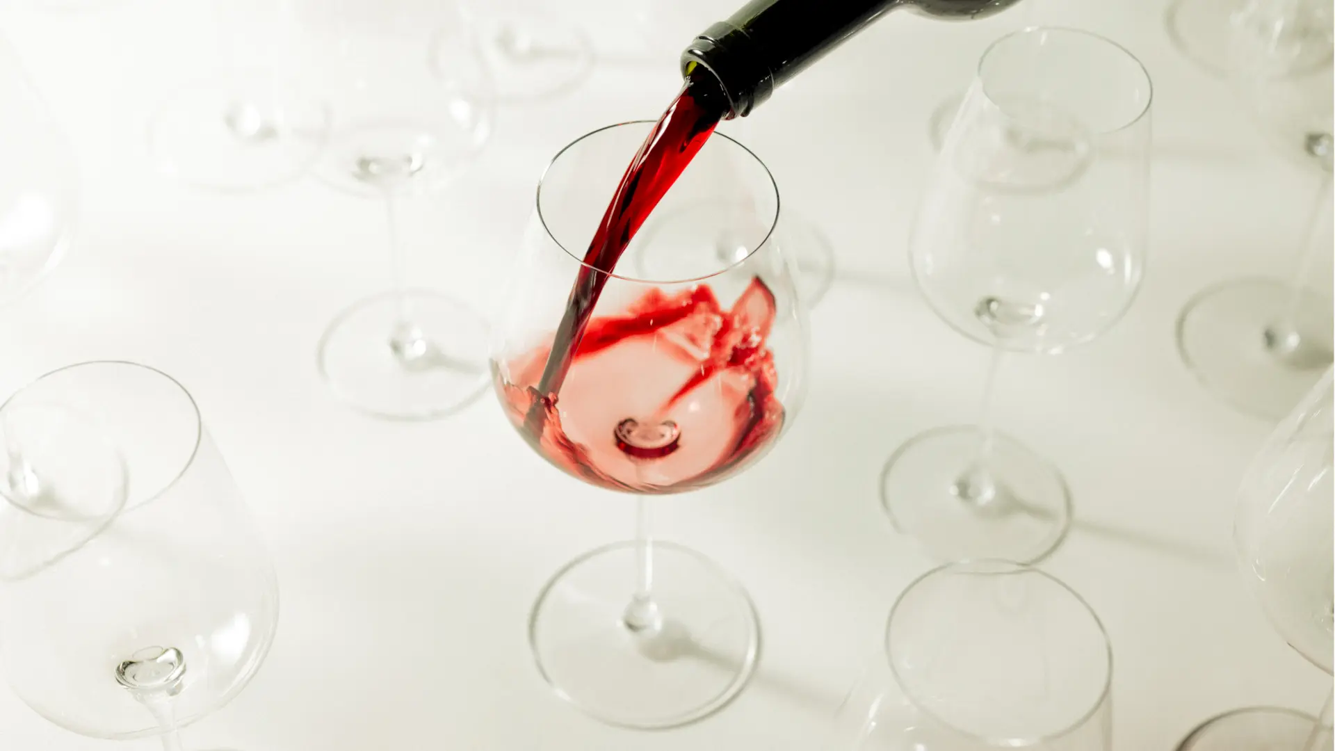 pouring red wine into wine glasses