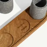Two stone cups placed on a wooden tray with the words "made in Mexico" engraved.