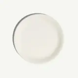 A plain white round plate is centered against a light background.