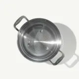 Stainless steel colander with two handles viewed from above.