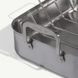 A close-up of a metal container with a handle featuring the words "MADE IN" engraved on it, suggesting the product's origin.