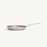 A metallic frying pan with a long handle is displayed against a plain white background.