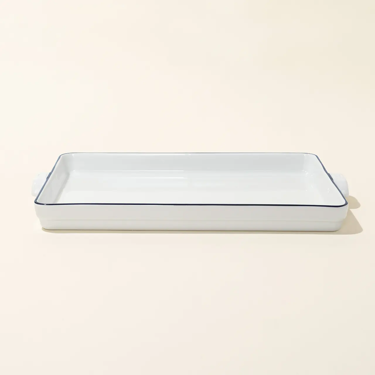 A rectangular ceramic baking dish with a blue rim on a neutral background.